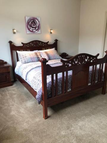1 dormitorio con cama de madera y almohadas en Central executive 3br townhouse 50m to dean street, en Albury