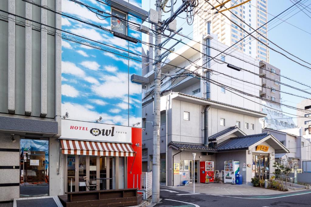 a city street with buildings and power lines at Hotel Owl Tokyo Nippori in Tokyo