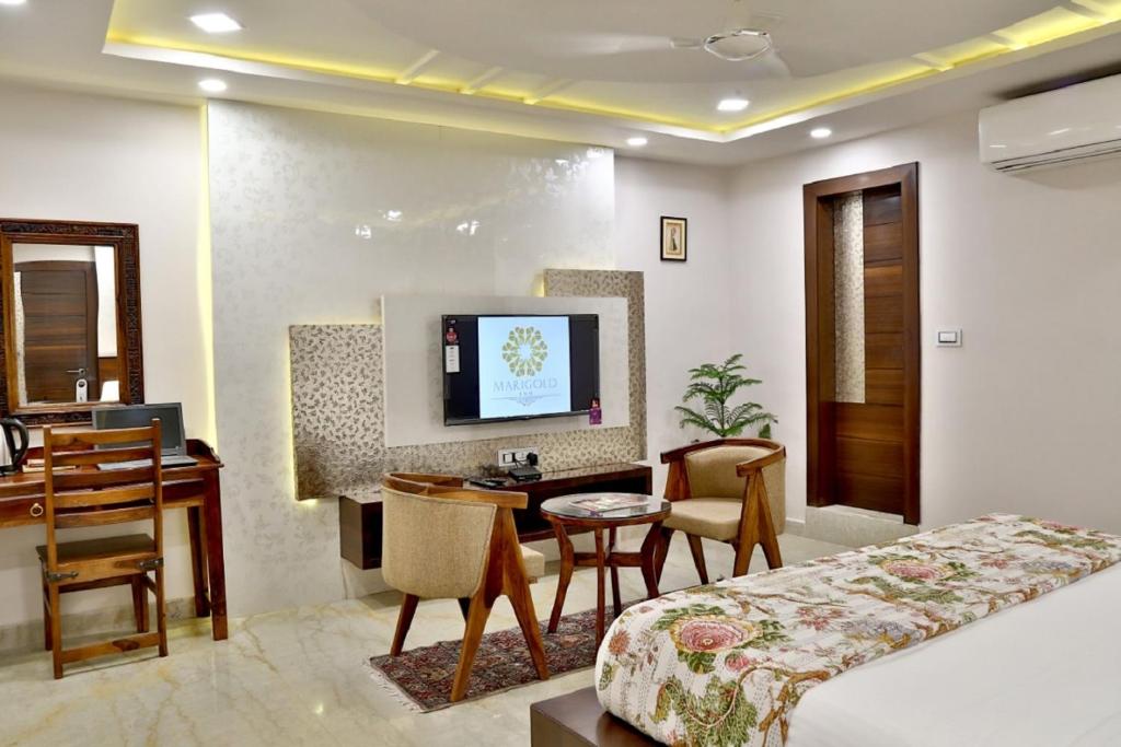 Marigold Inn- Homestay في جايبور: غرفة فندقية فيها سرير ومكتب وتلفزيون
