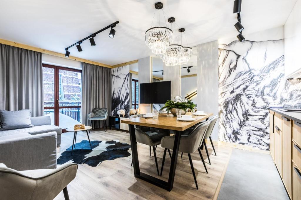 - une cuisine et une salle à manger avec une table et des chaises dans l'établissement Apartament SKI, à Zakopane