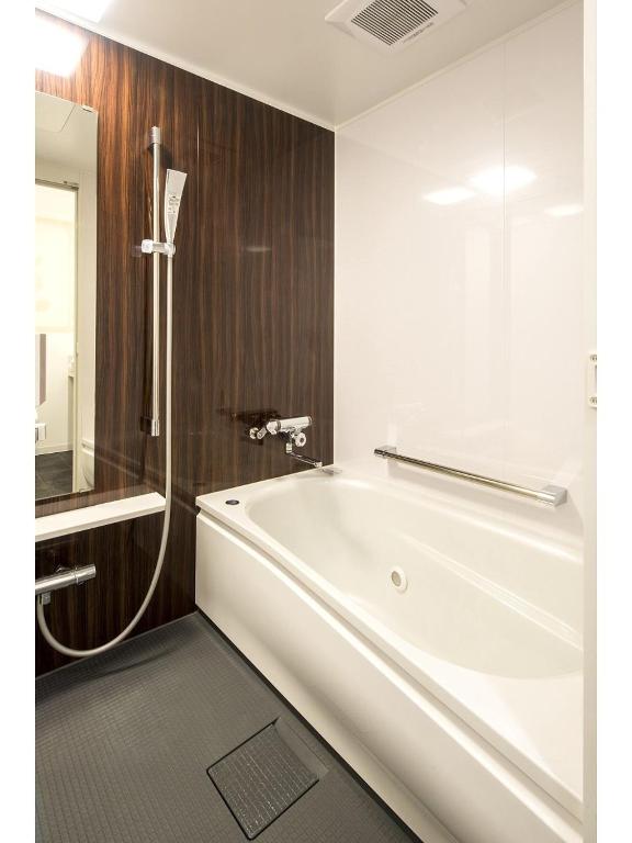 a bathroom with a white tub and a shower at Sejour Inn Nagarekawa in Hiroshima