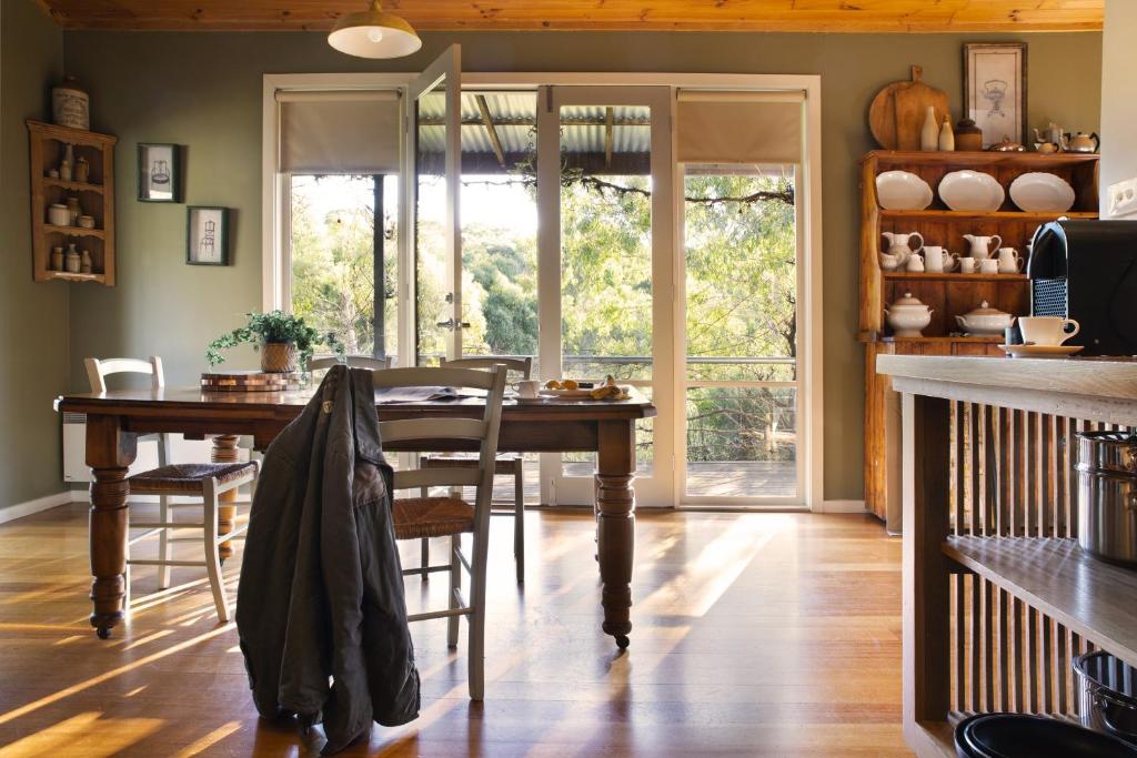 a dining room with a wooden table and chairs at Kookaburra Ridge in Hepburn