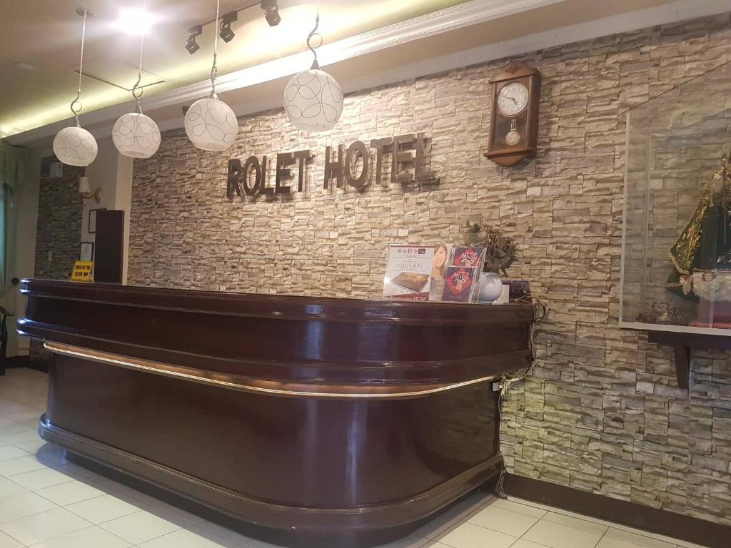een bar in een restaurant met een bord op een bakstenen muur bij ROLET HOTEL in Catbalogan