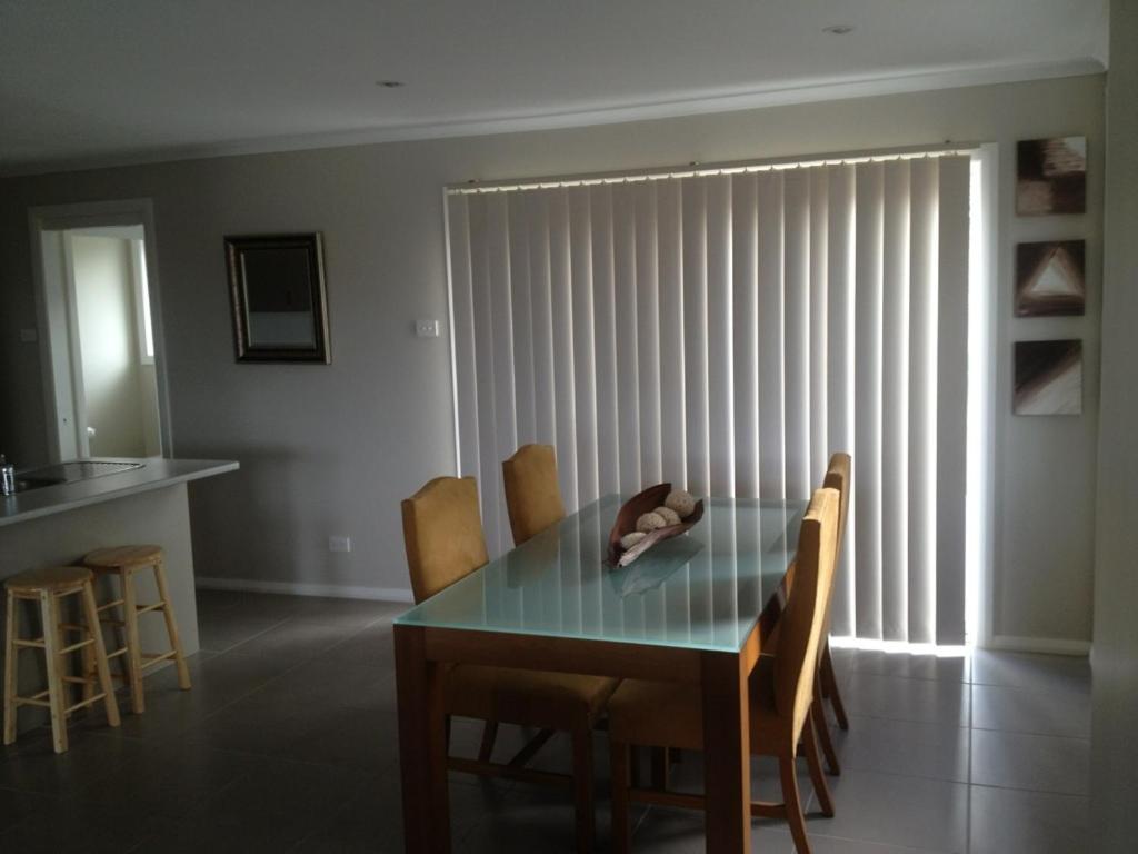 
a dining room table and chairs in a room at Denman Serviced Apartments in Denman
