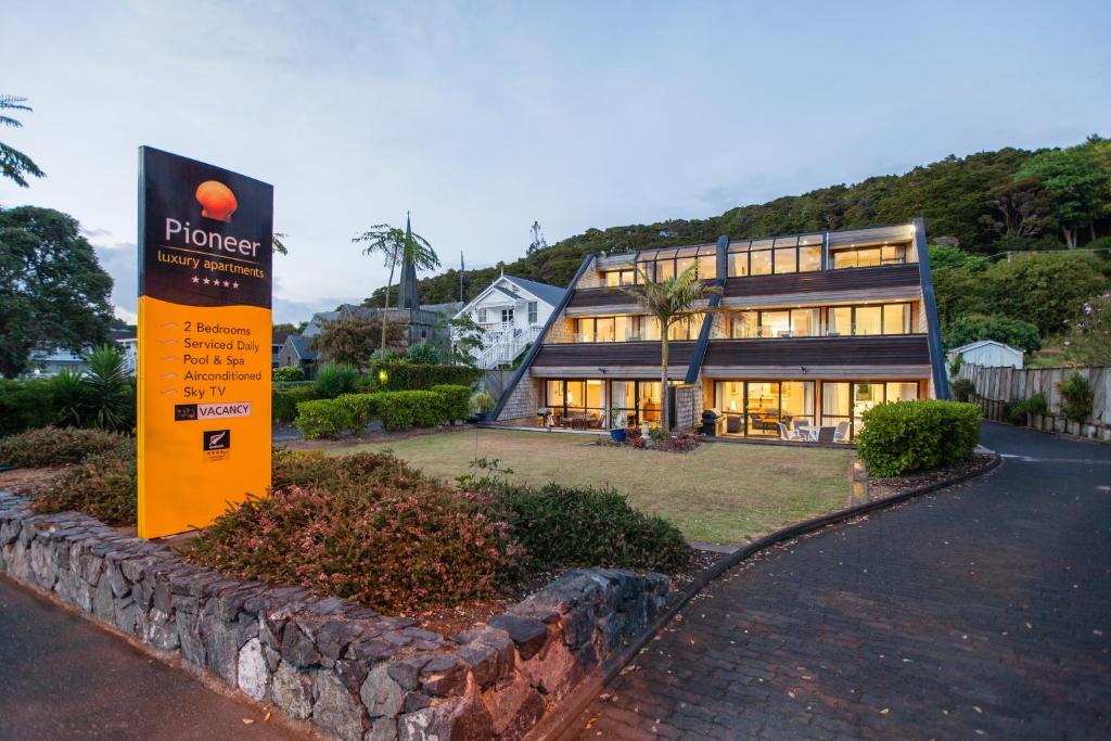a building with a sign in front of it at Pioneer Waterfront Apartments in Paihia