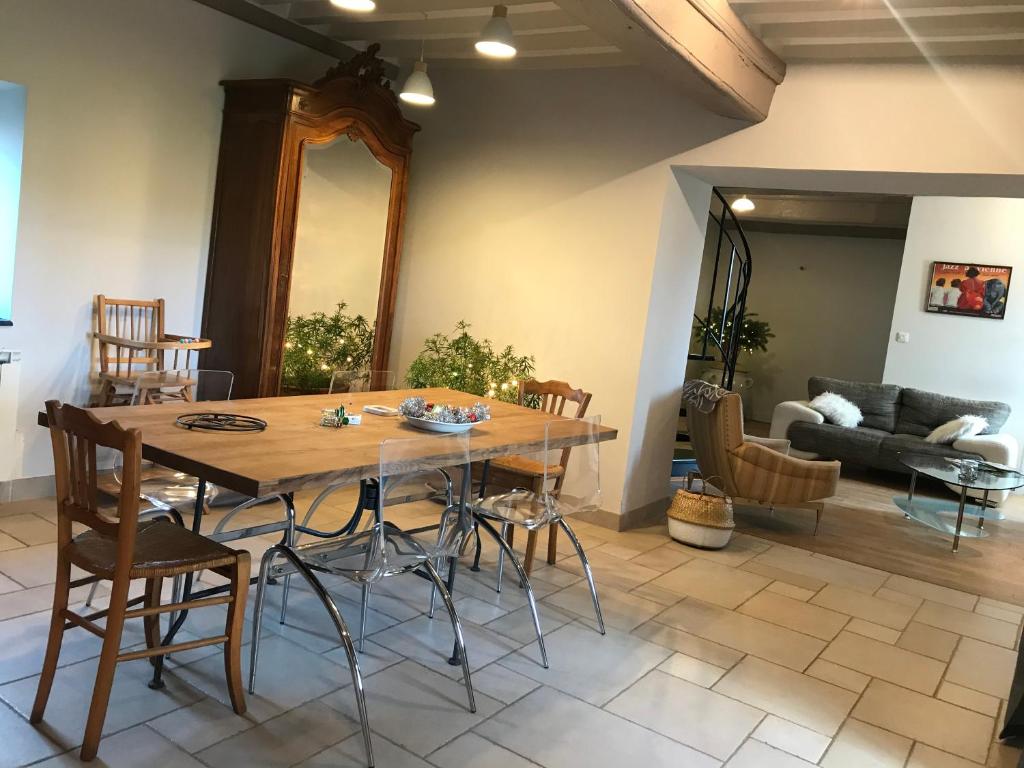 a dining room with a wooden table and chairs at Les Marguerites in Palinges