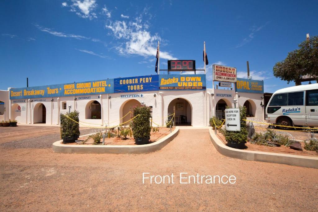 Ein Bus steht vor einem Vordereingang. in der Unterkunft Radeka Downunder Underground Motel in Coober Pedy