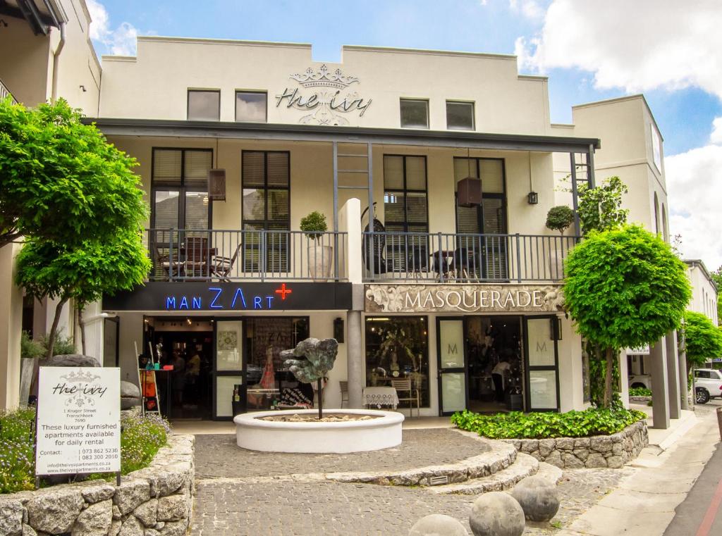 ein Gebäude mit einem Brunnen davor in der Unterkunft The Ivy Apartments Franschhoek in Franschhoek