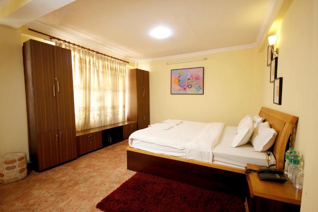 1 dormitorio con cama, escritorio y ventana en Hotel Mountain Gateway, en Katmandú