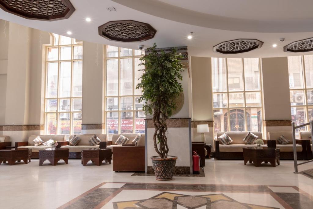un vestíbulo con sofás y una maceta en Dhiafat Al Raja Hotel, en La Meca
