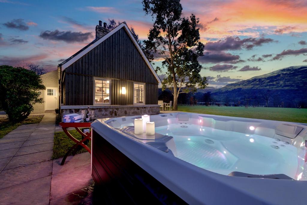a jacuzzi tub in front of a house at Dalveich Cottage, hot tub, 2 bedroom, Lochearnhead in Lochearnhead