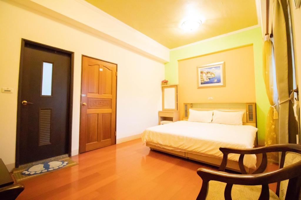 a bedroom with a bed and a wooden floor at Wenxin Homestay in Hualien City