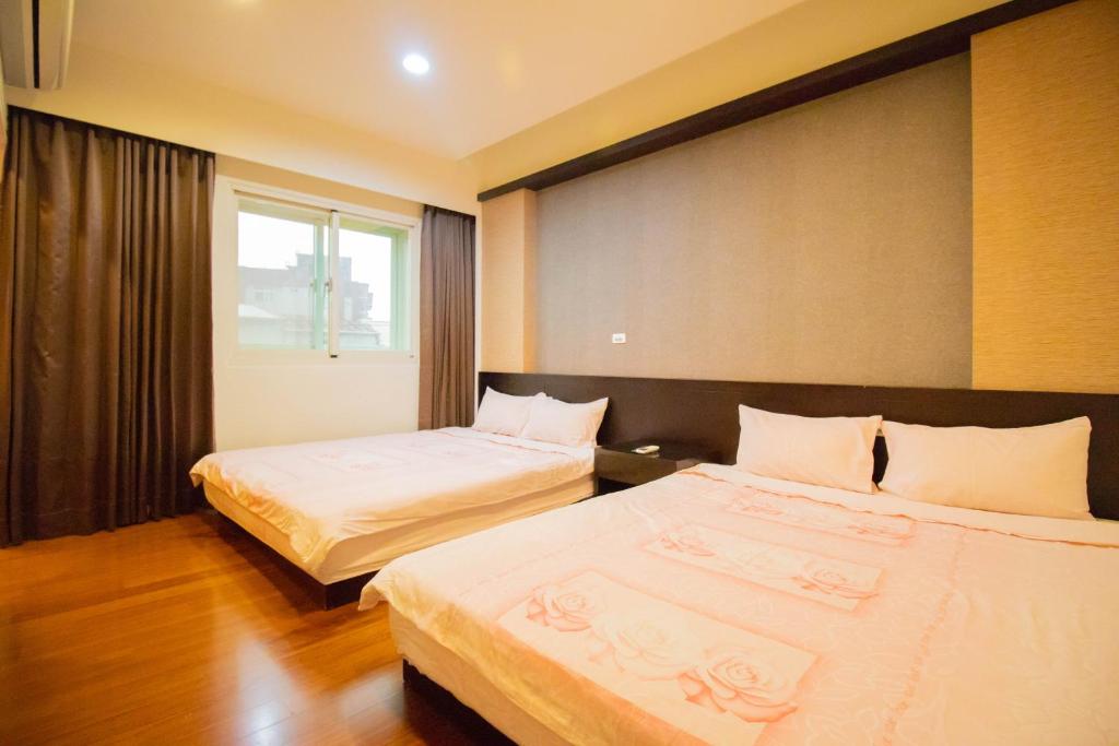 a hotel room with two beds and a window at Wenxin Homestay in Hualien City
