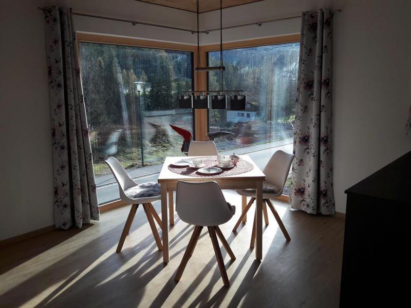 a dining room table and chairs in front of a window at Chalet Vacanza in Brand