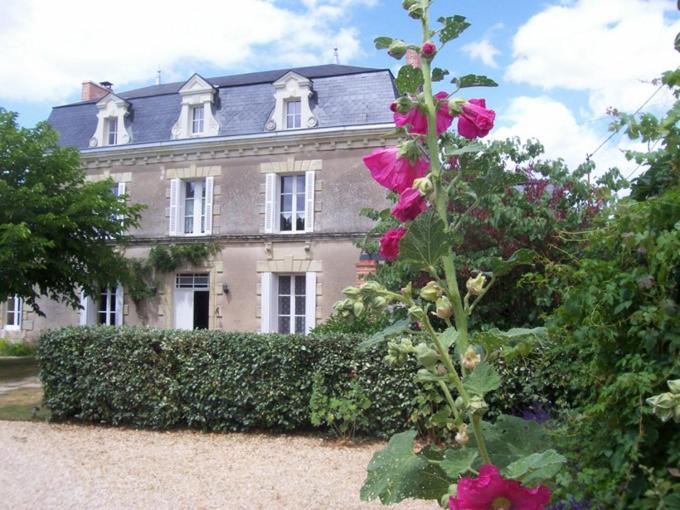 a house with a flowering bush in front of it at La Jariette in Airvault