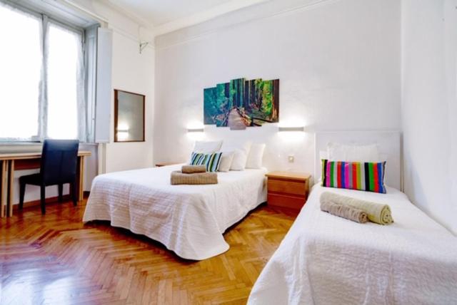 a white room with two beds and a desk at Alessia's Flat- Loreto 2 in Milan