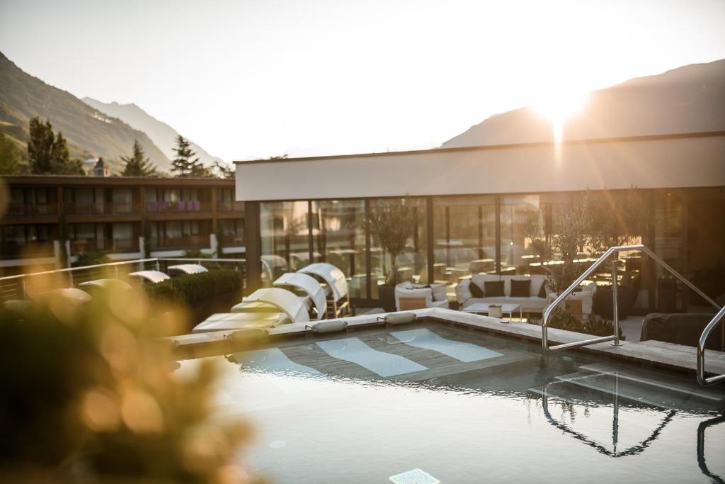 un complexe avec une piscine et un bâtiment dans l'établissement Sonnen Resort, à Naturno