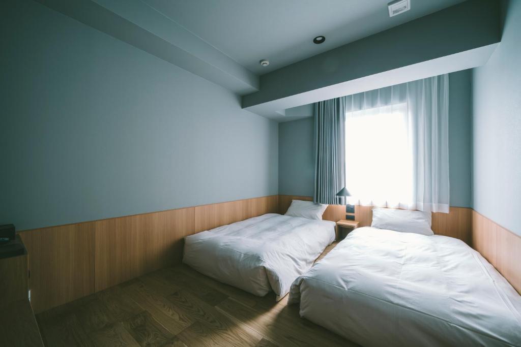 Postel nebo postele na pokoji v ubytování LANDABOUT TOKYO