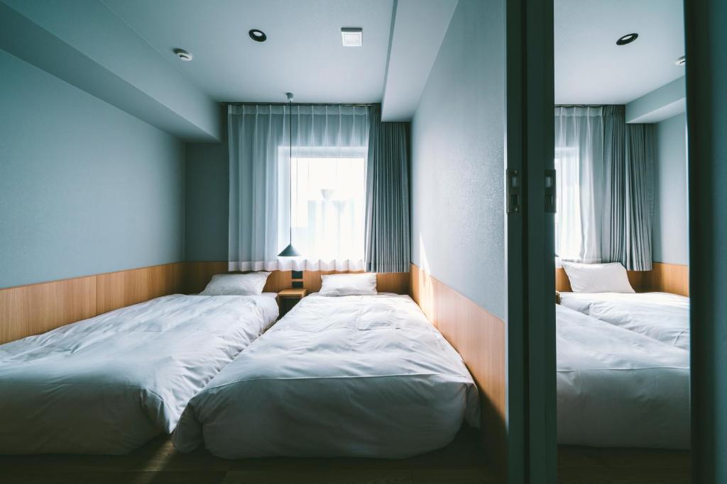 Postel nebo postele na pokoji v ubytování LANDABOUT TOKYO