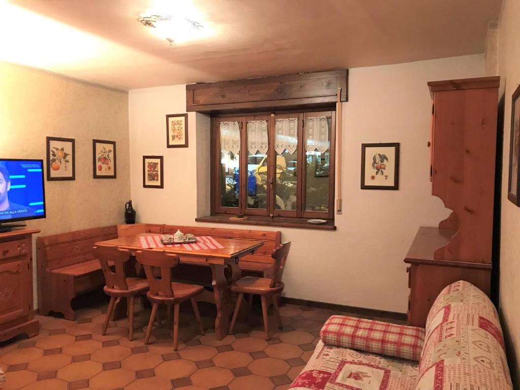 une salle à manger avec une table et une télévision dans l'établissement Home Christiania by Holiday World, à Sauze dʼOulx