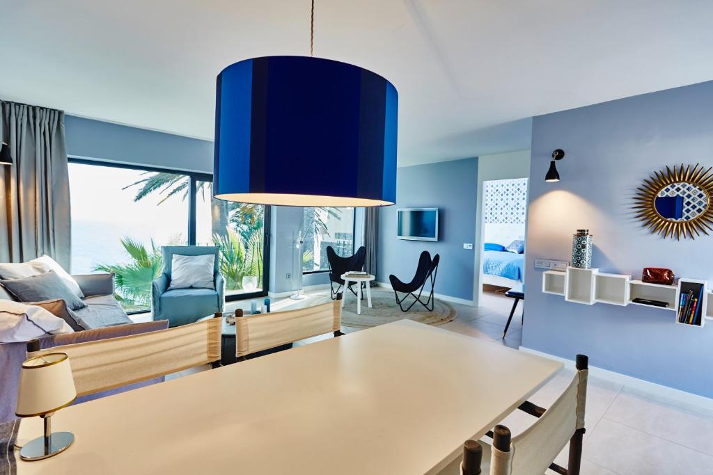 ein Wohnzimmer mit Tisch und Couch in der Unterkunft Boutique Sea View Apartment in San Agustin in San Agustín