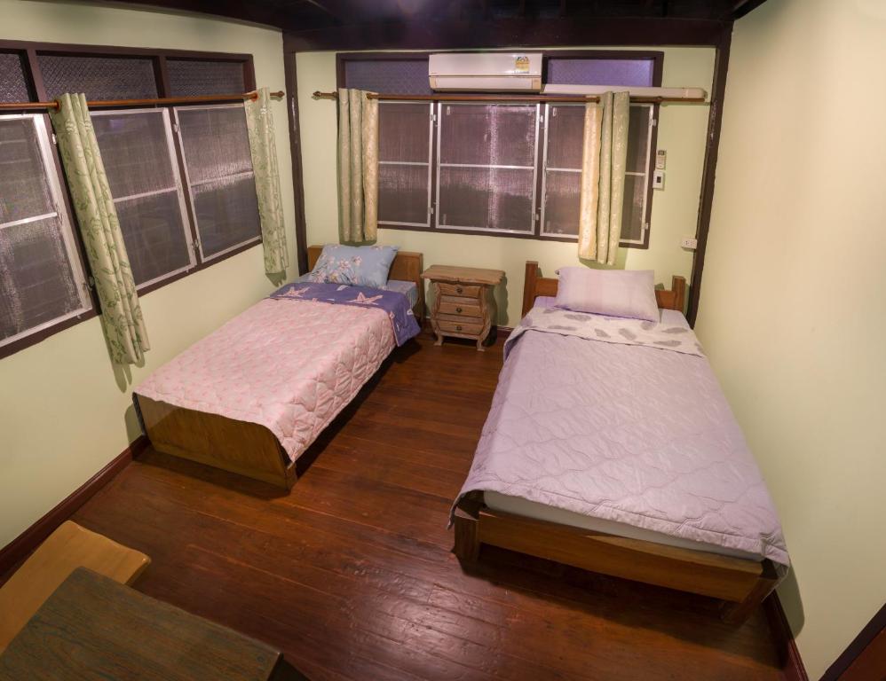 two beds in a room with two windows at Yesterday Sathon in Bangkok
