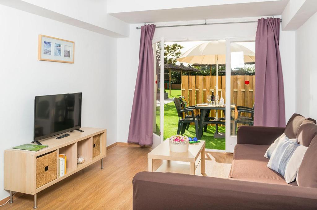 a living room with a couch and a tv at Apartaments Els Llorers in Lloret de Mar