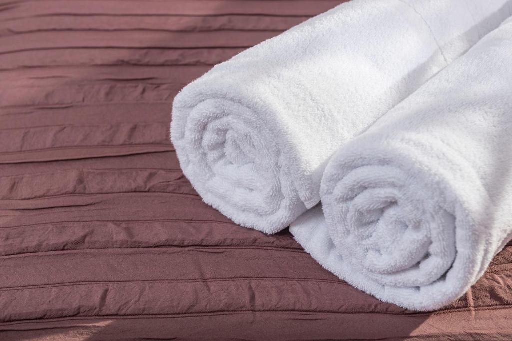 a white towel on top of a bed at Apartaments Els Llorers in Lloret de Mar