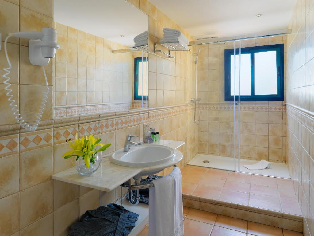a bathroom with a sink and a shower at H10 Playa Esmeralda - Adults Only in Costa Calma