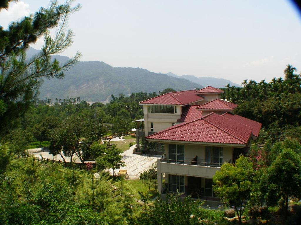 a house with a red roof on a hill at Zen and Pine Resort in Shuili