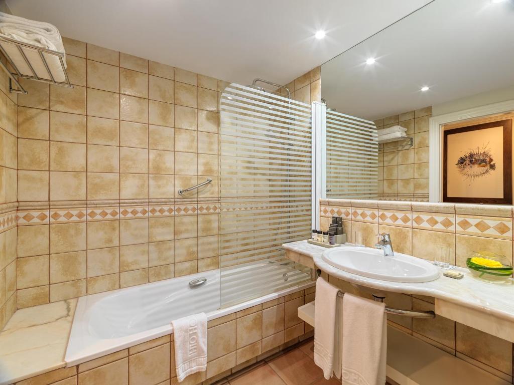 a bathroom with a bath tub and a sink at H10 Playa Esmeralda - Adults Only in Costa Calma
