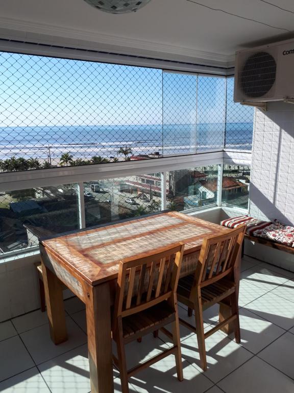 d'une table et de chaises sur un balcon avec vue sur l'océan. dans l'établissement Apartamento em frente a praia, à Praia Grande