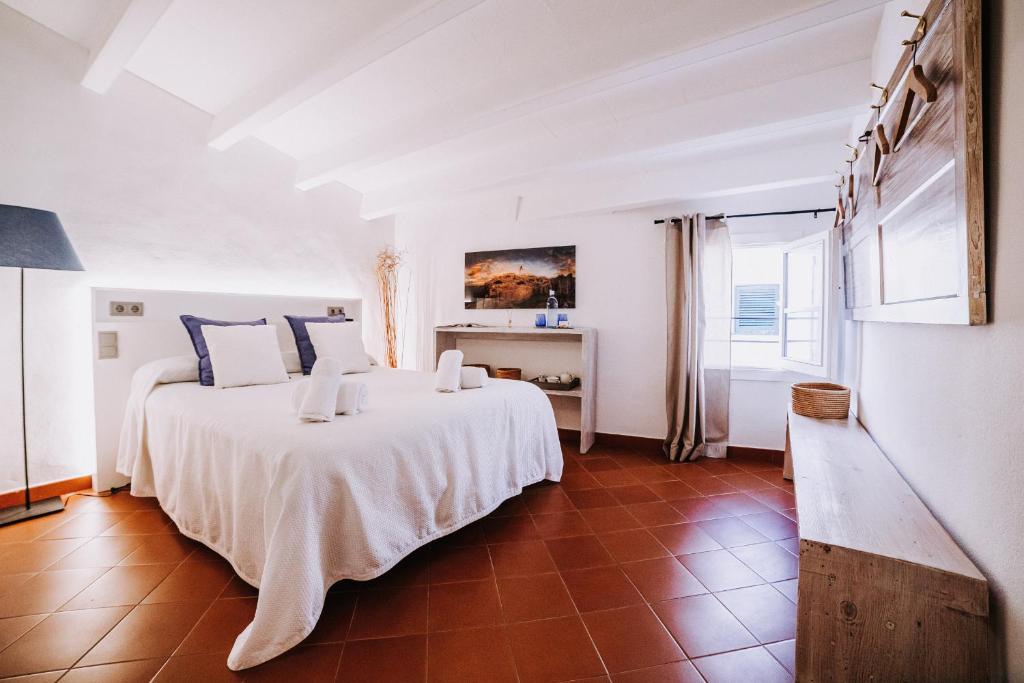 Un dormitorio con una gran cama blanca y una ventana en Petit Hotel 5 Fars, en Ciutadella