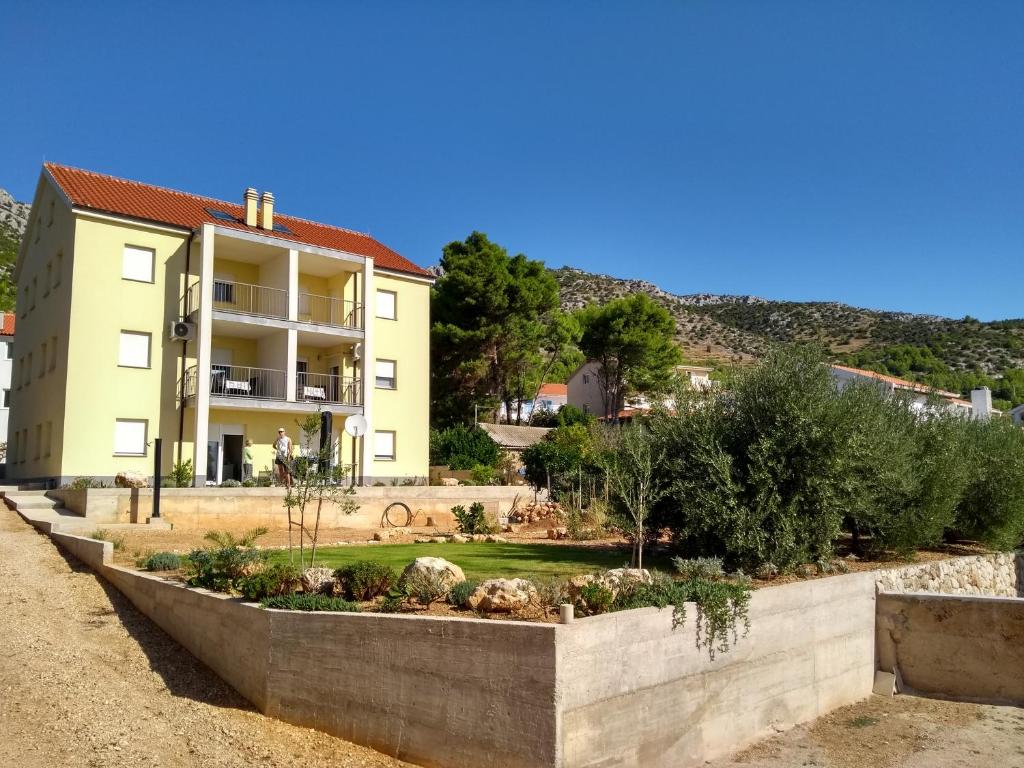 un jardin en face d'un bâtiment dans l'établissement Hvar Apartment, à Zavala