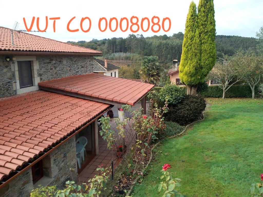 una casa con techo rojo y patio en Casa Rural Oza dos Ríos, en Oza dos Ríos