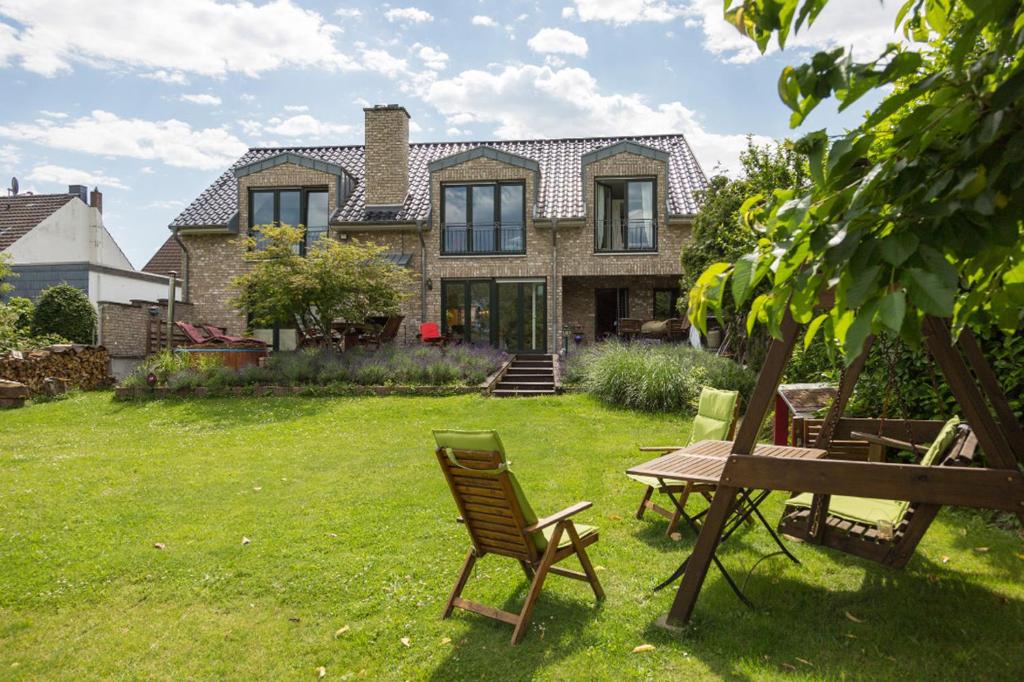 een huis met een tafel en stoelen in de tuin bij Schönste Lage am Rhein in unmittelbarer Stadtnähe, B & B in Keulen