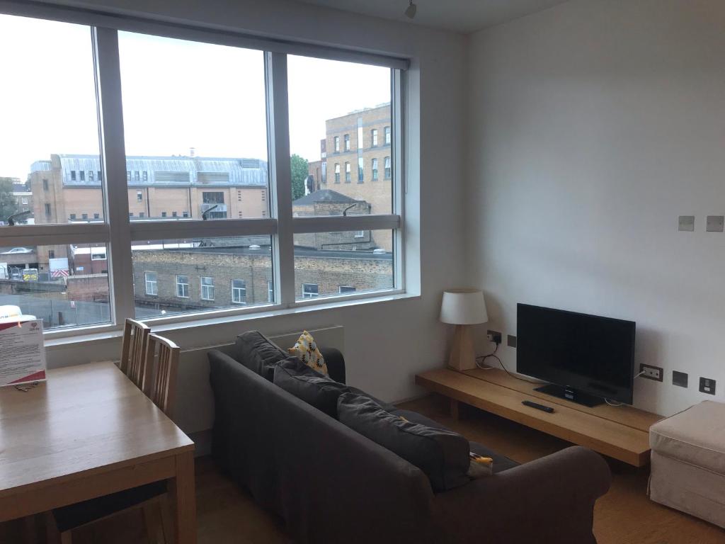 a living room with a couch and a flat screen tv at King's Cross Deluxe Serviced Apartments in London