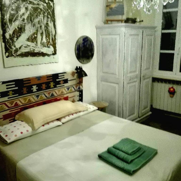 um quarto com uma cama com duas toalhas verdes em Studiocasarte em Ovada