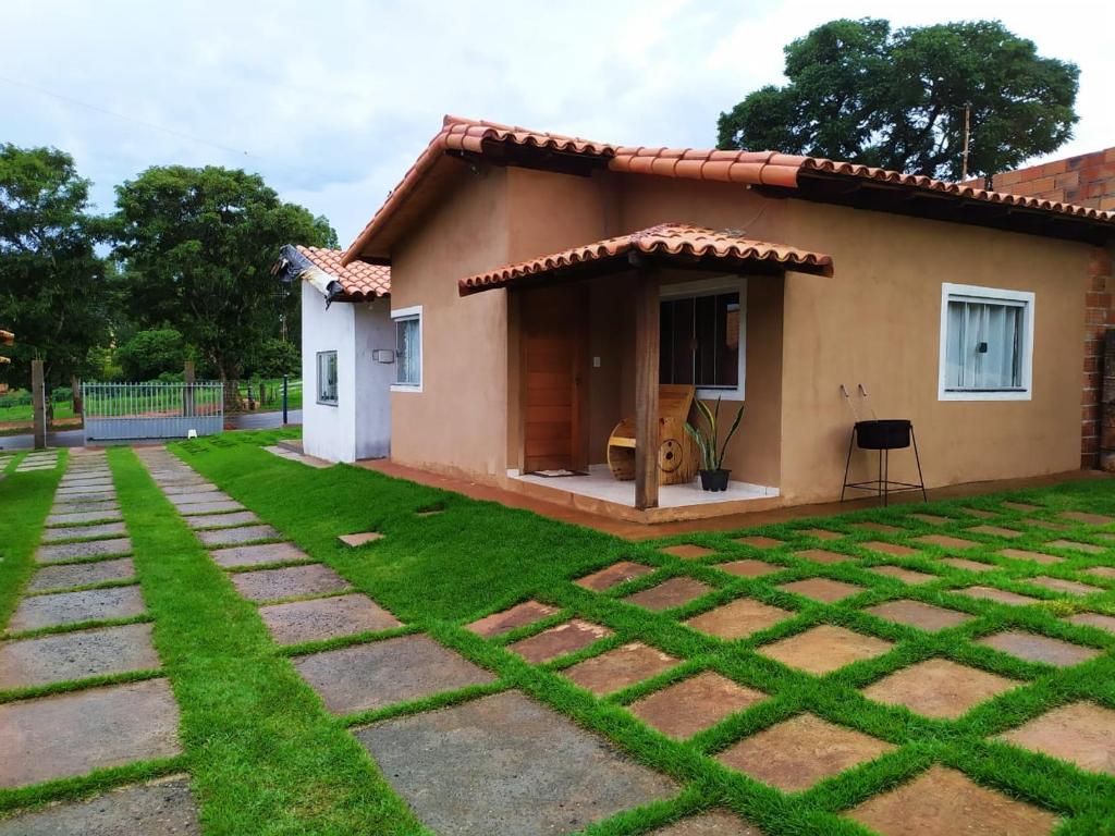 a small house with a grassy yard in front of it at casa temporada capitólio in Capitólio