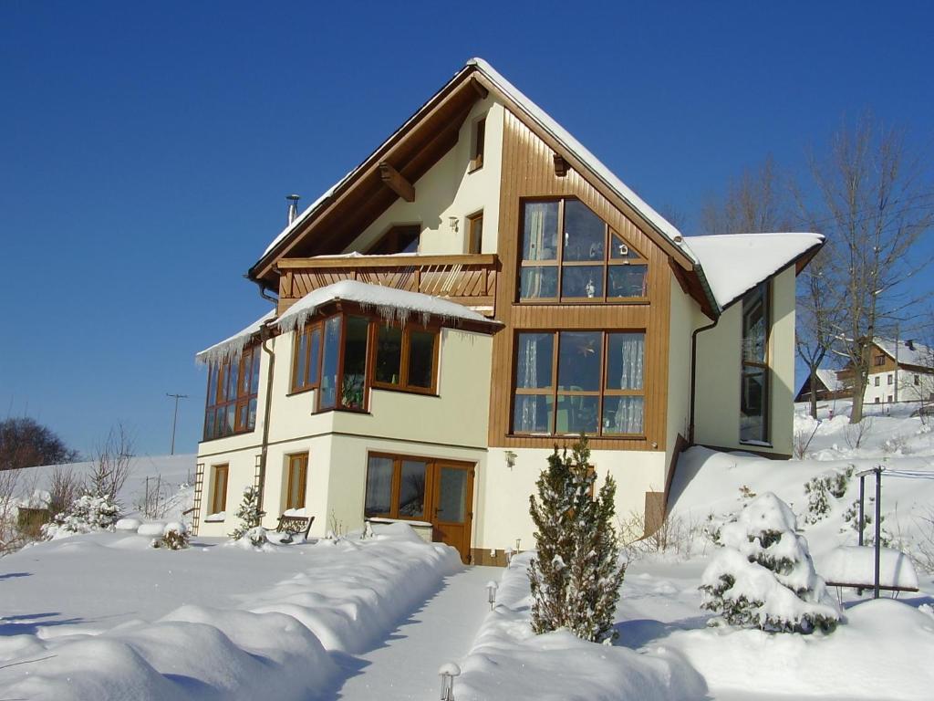 uma casa com neve em frente em Ferienwohnung Lang em Breitenbrunn