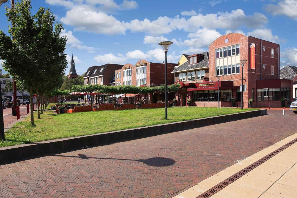 una calle en una ciudad con edificios y un semáforo en Hotel Parkzicht en Veendam