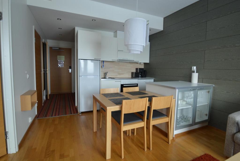 a kitchen with a table and chairs and a refrigerator at Ylläshuiput in Ylläsjärvi