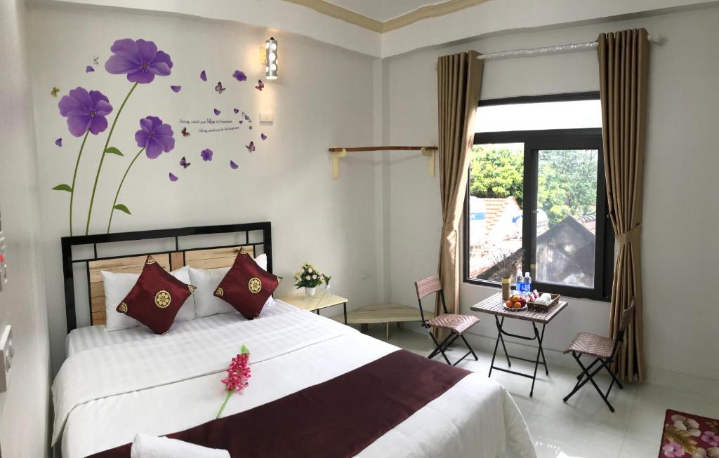 - une chambre avec un lit orné de fleurs violettes sur le mur dans l'établissement Thăng Loan Tam Cốc Hostel, à Ninh Binh
