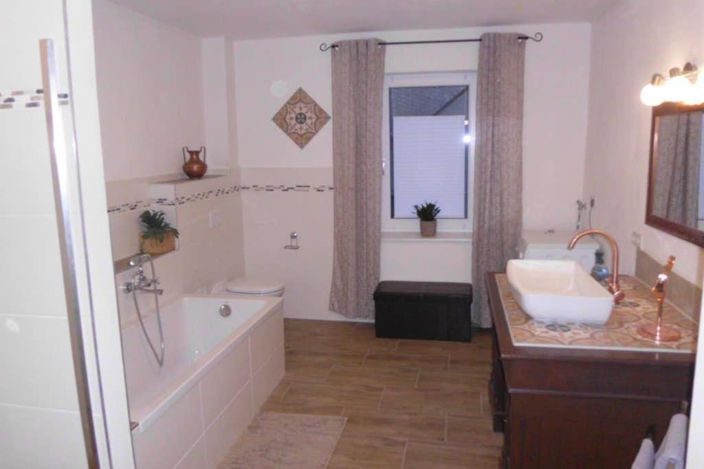 a bathroom with a tub and a sink and a bath tub at Sinnes Wandel Hof Serka in Grimma