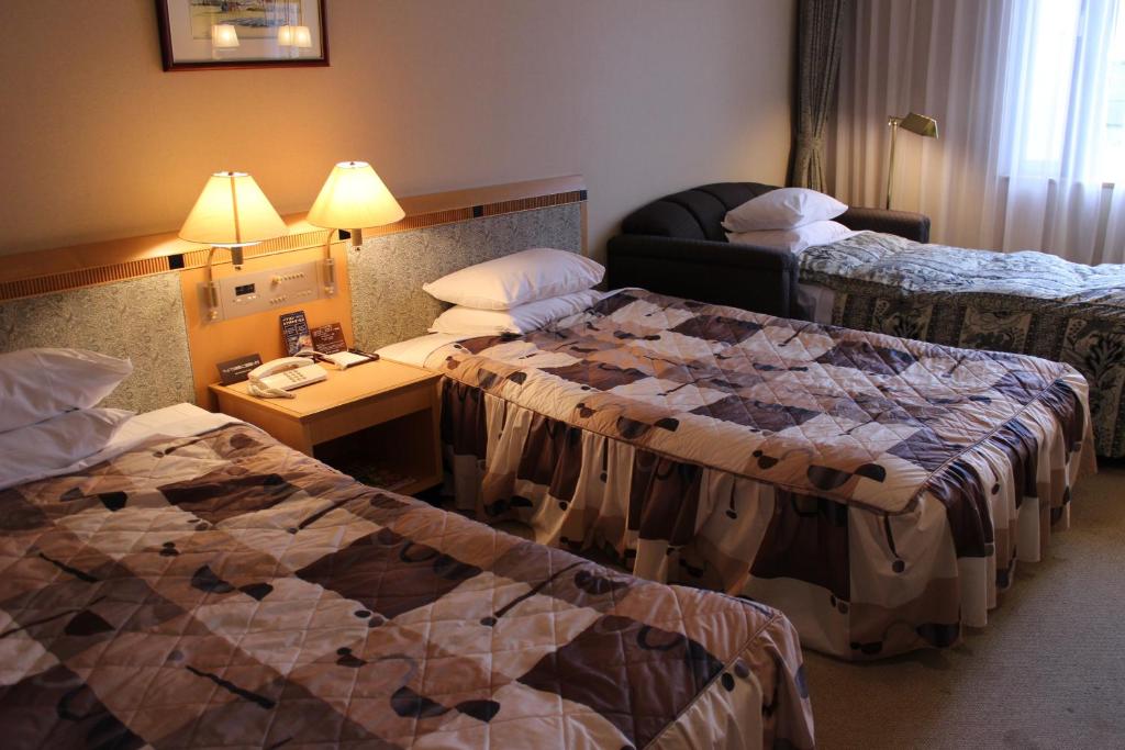 Postel nebo postele na pokoji v ubytování Grand Hotel Hakusan