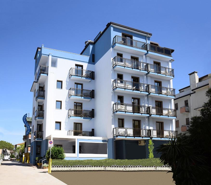 a white building with balconies on the side of it at Hotel Ondina in Lido di Jesolo