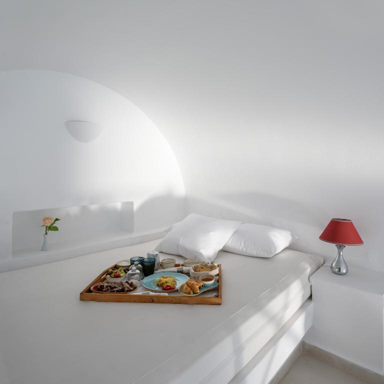 a tray of food sitting on a white table at Above Blue Suites in Imerovigli