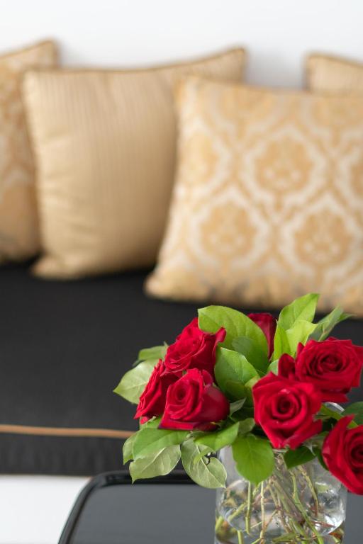 a vase filled with red roses on a table at Above Blue Suites in Imerovigli