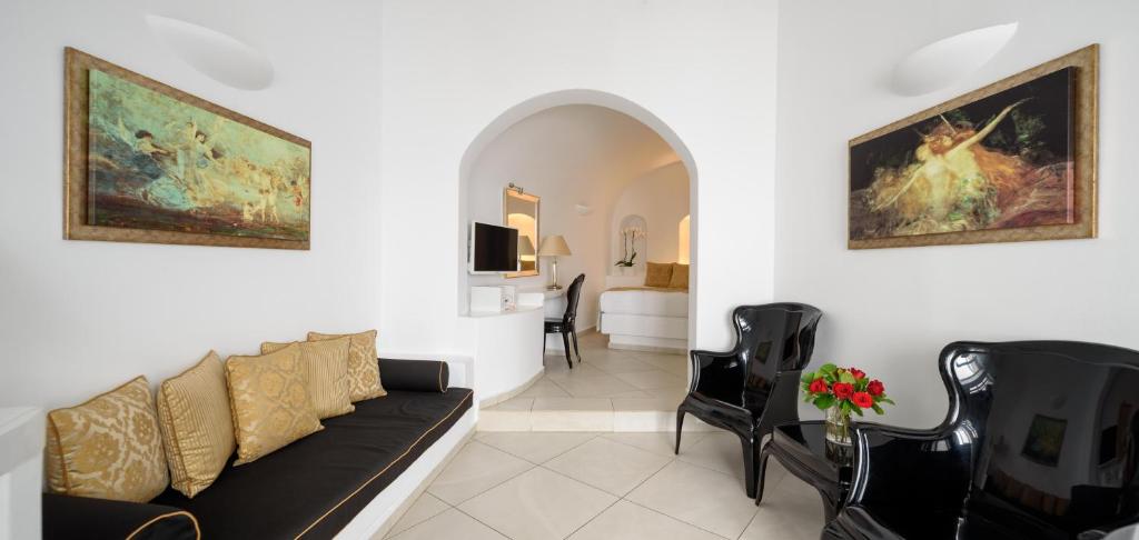 a living room with a couch and chairs and a bedroom at Above Blue Suites in Imerovigli