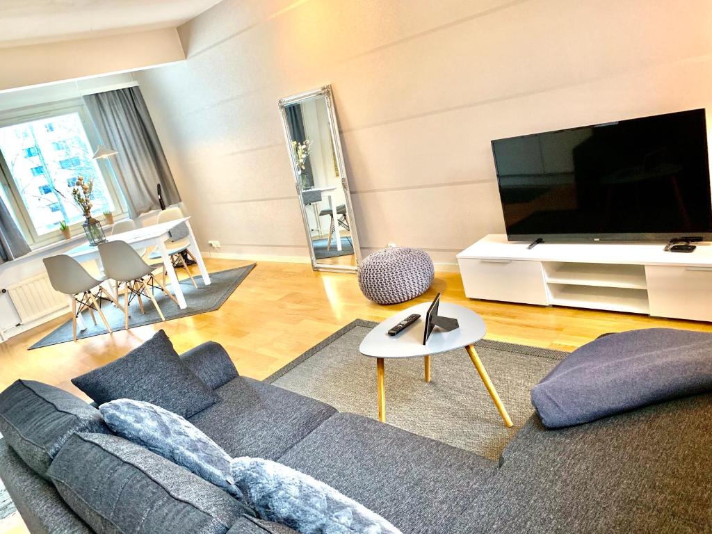 sala de estar con sofá y TV de pantalla plana en DP Apartments Vaasa II, en Vaasa